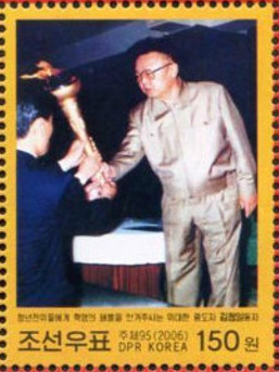 Colnect-3102-396-Kim-Jong-Il-with-torch.jpg