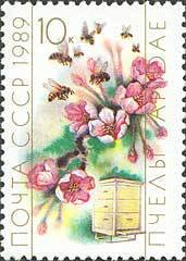Colnect-580-235-Honeybee-Apis-mellifica-Flowers-and-Hive.jpg