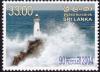 Colnect-3041-155-Lighthouse-and-tsunami-wave.jpg