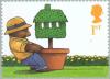 Colnect-123-551-Bear-pulling-Potted-Topiary-Tree-Moving-Home.jpg